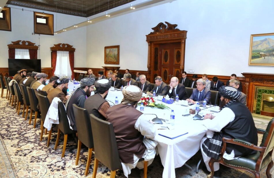 The photo depicts Amir Khan Muttaqi, the Acting Minister of Foreign Affairs for the Islamic Emirate of Afghanistan, during a meeting with a foreign delegation.