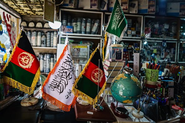 Flag of the Afghan Taliban featuring a plain white background with a black Shahada, the Islamic proclamation of faith, written in Arabic script. The flag symbolizes religious commitment and the Taliban's interpretation of Islamic governance.