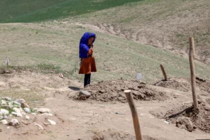 In Baghlan, a child stands by the grave of a family member who died due to the floods. Dozens of recent flood victims are buried in this area.