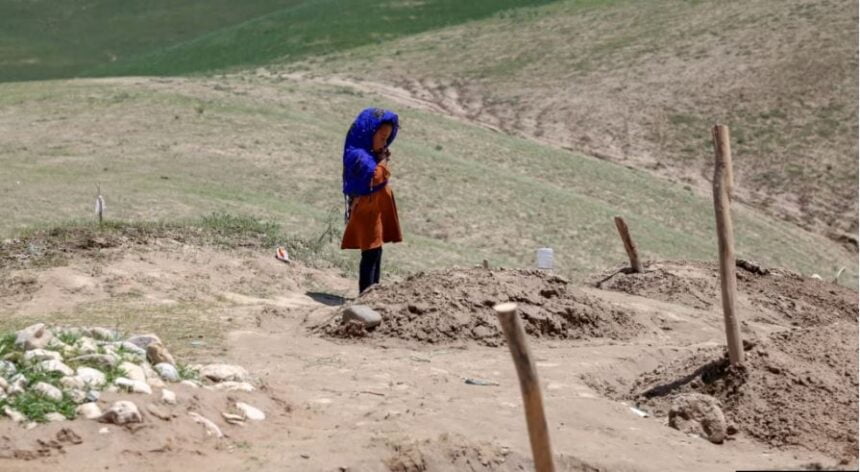 In Baghlan, a child stands by the grave of a family member who died due to the floods. Dozens of recent flood victims are buried in this area.