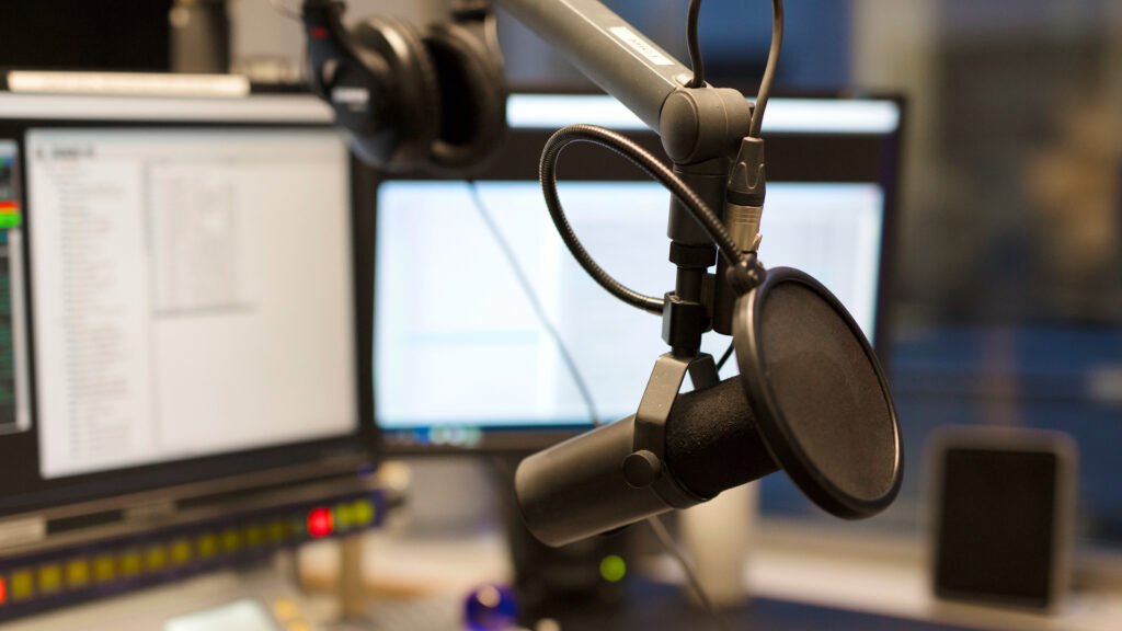 Studio microphone in front of radio station broadcasting equipment