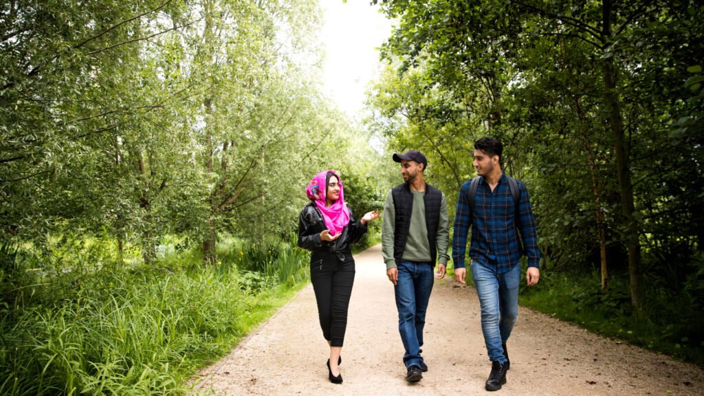A group of friends who seems to be refugees walking on the pathway in the park